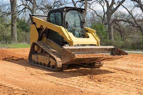 grading with a skid steer|leveling ground with skid steer.